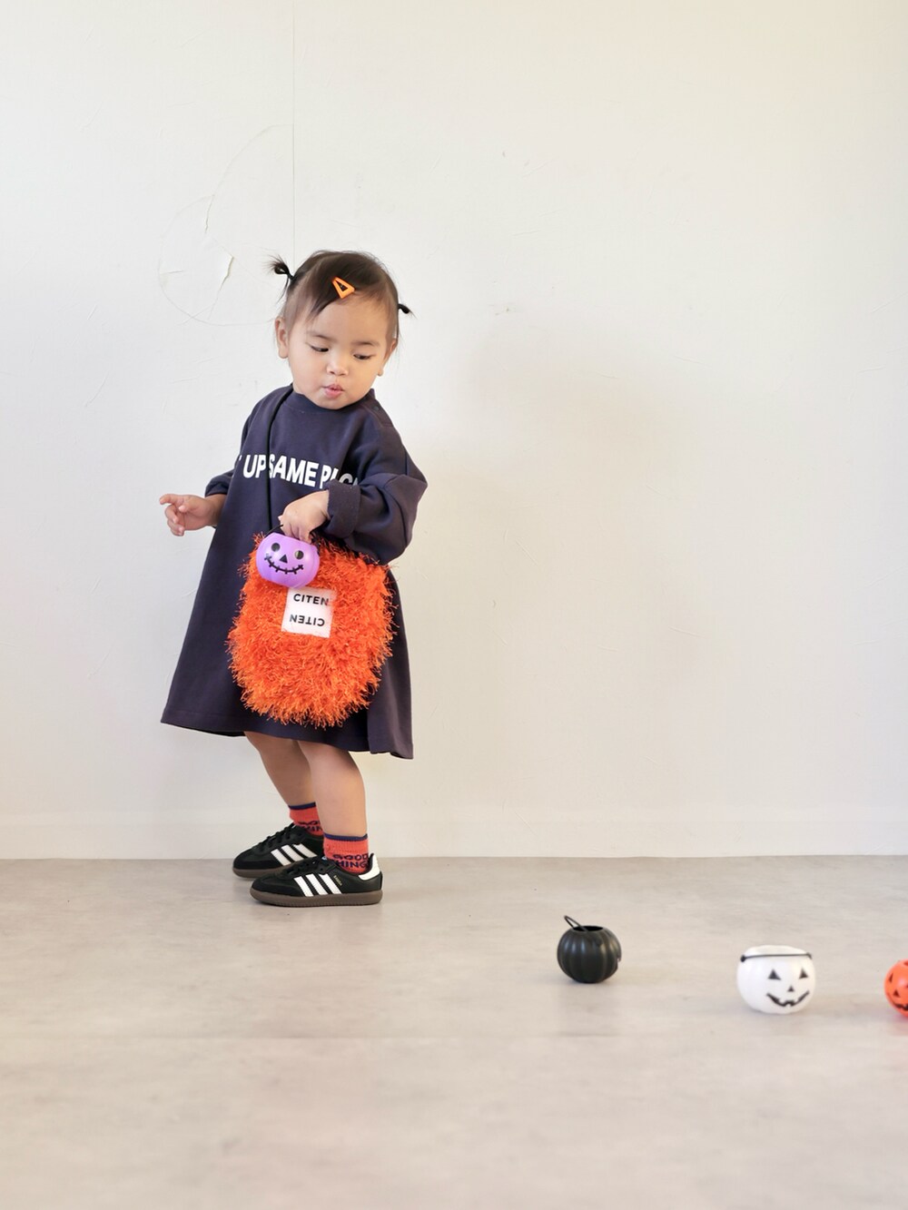 ブルー系のワンピース、オレンジ系のショルダーバッグ、ブラック系のスニーカーを着用したキッズの秋コーディネートの2枚目の写真