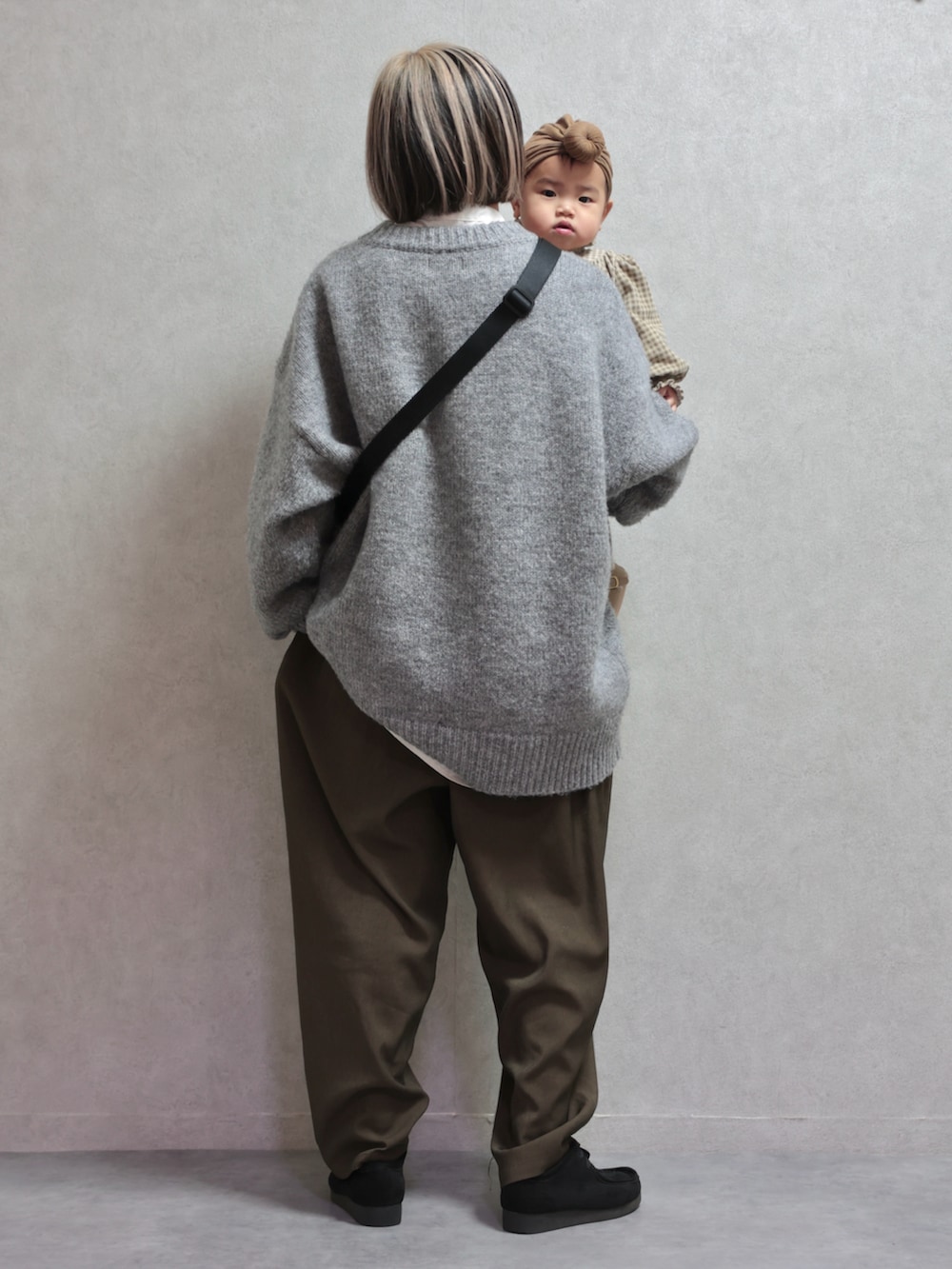 グレー系のニット/セーター、グリーン系のスラックス、ブラック系のモカシン/デッキシューズを着用したキッズの冬コーディネートの4枚目の写真