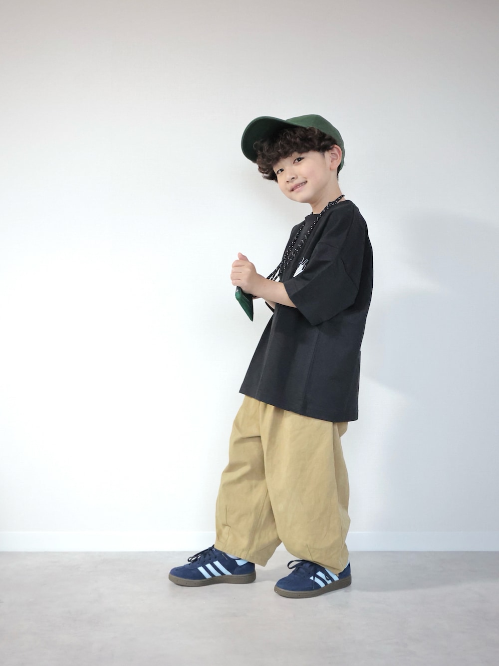 ブラック系のTシャツ/カットソー、ブラウン系のその他パンツ、ブルー系のスニーカーを着用したキッズの春コーディネートの5枚目の写真