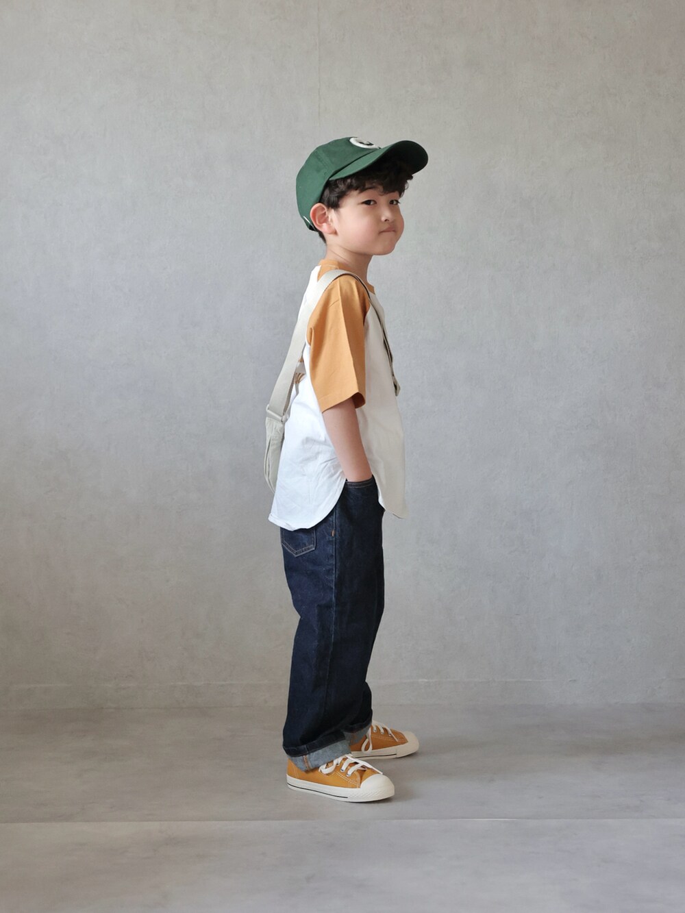 イエロー系のTシャツ/カットソー、ブルー系のデニムパンツ、イエロー系のスニーカーを着用したキッズの春コーディネートの4枚目の写真