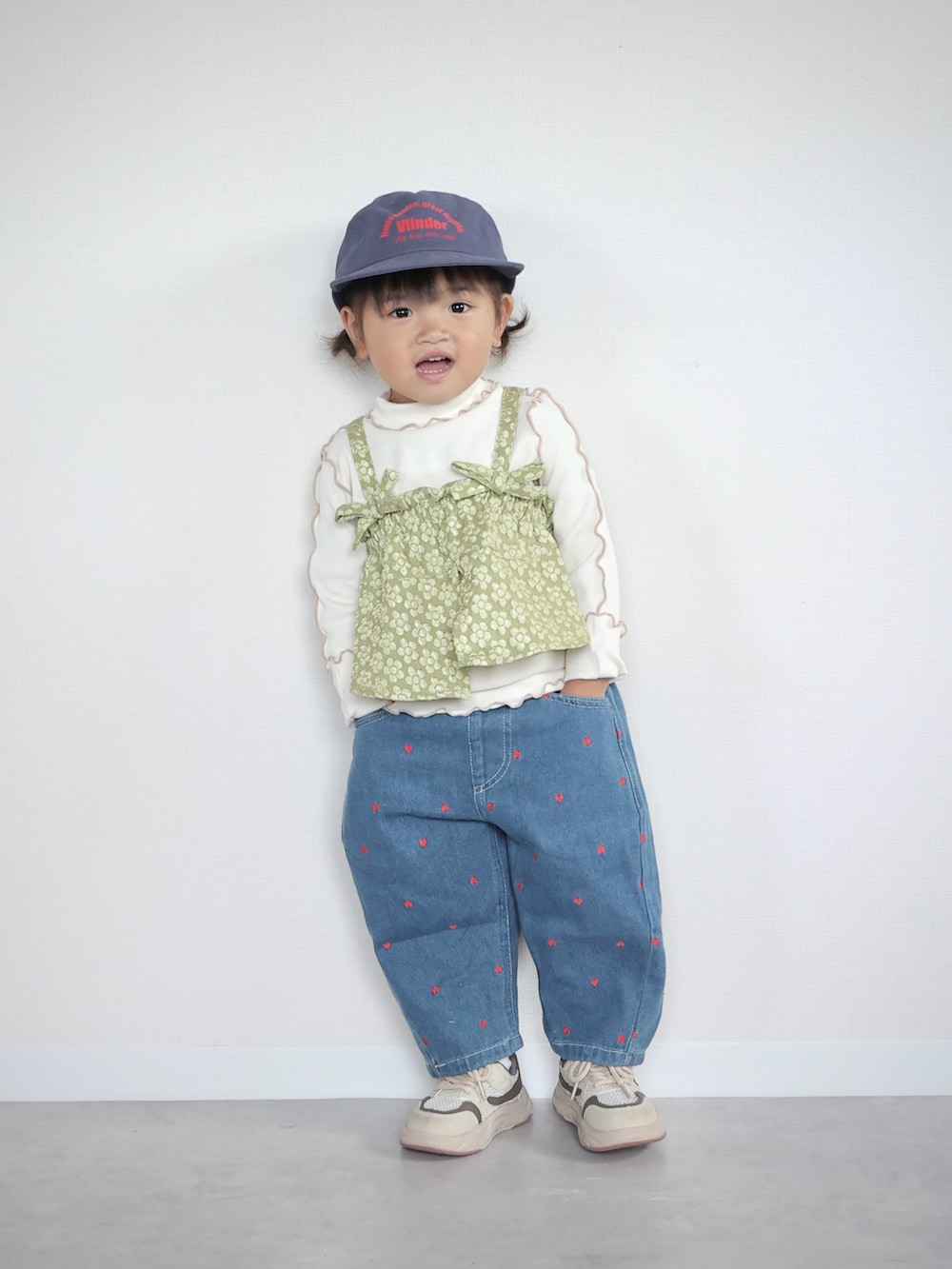 ベージュ系のスニーカー、グリーン系のTシャツ/カットソー、ブルー系のデニムパンツを着用したキッズの夏コーディネートの2枚目の写真