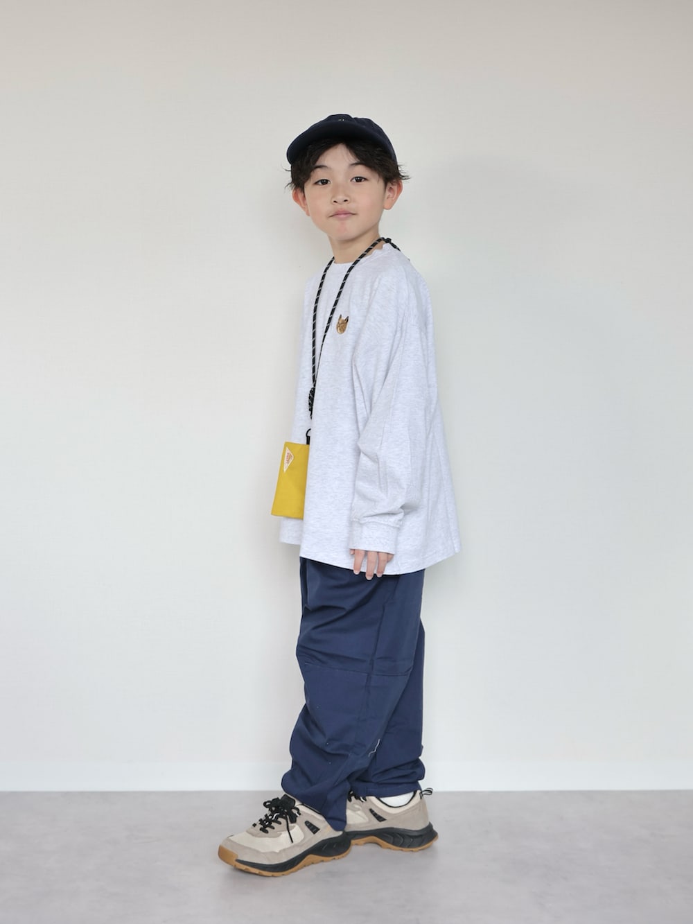 グレー系のTシャツ/カットソー、ブルー系のデニムパンツ、ベージュ系のスニーカーを着用したキッズの冬コーディネートの3枚目の写真