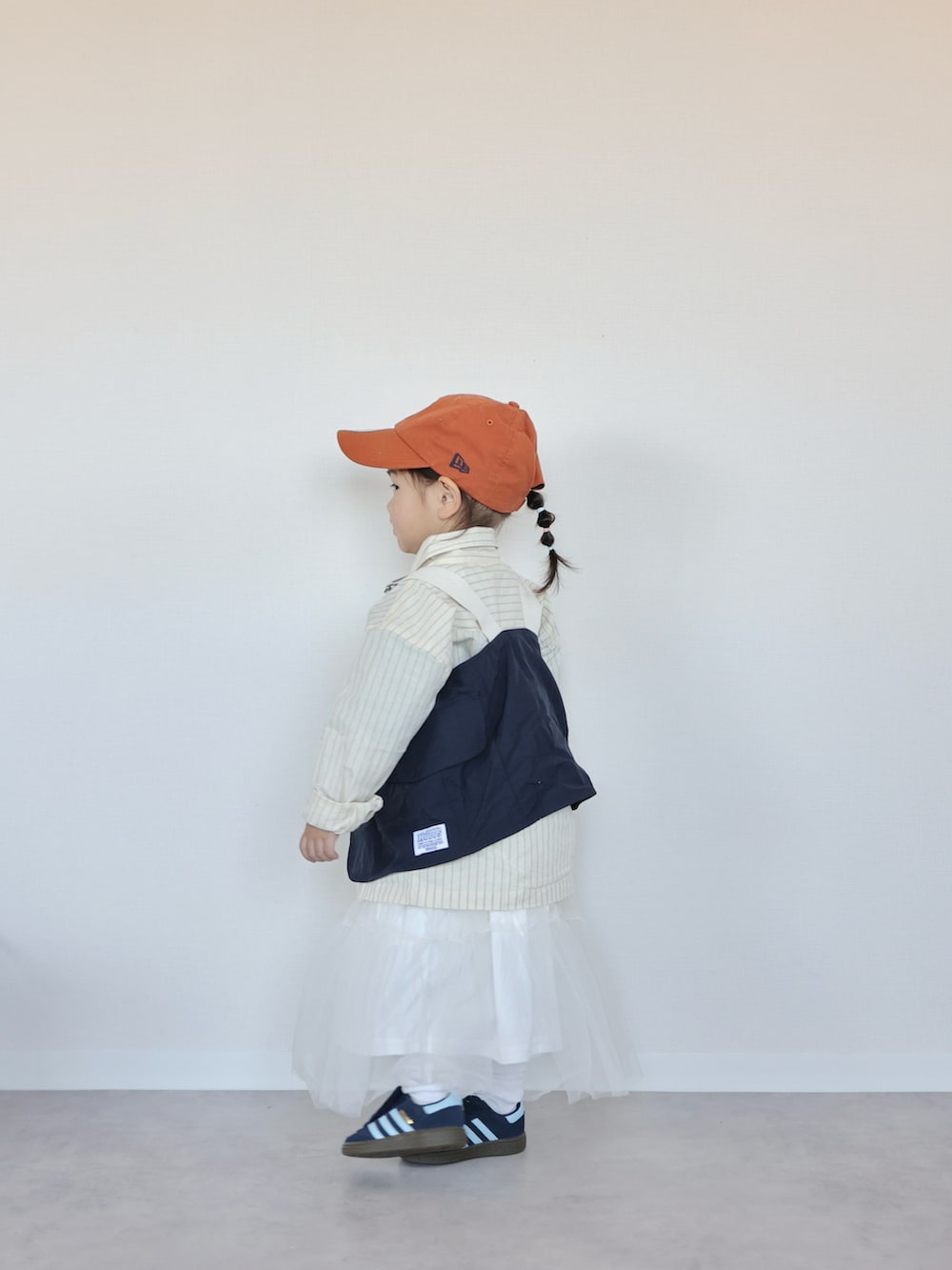 イエロー系のシャツ/ブラウス、ブルー系のベスト、ホワイト系のスカートを着用したキッズの春コーディネートの5枚目の写真