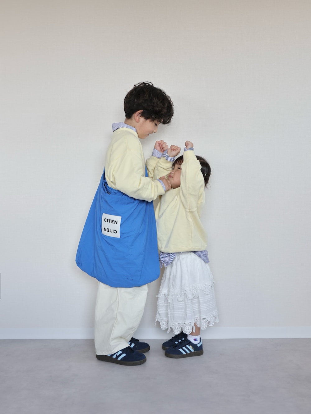 イエロー系のトップス、ブルー系のシャツ/ブラウス、ホワイト系のカーゴパンツを着用したキッズの春コーディネートの3枚目の写真