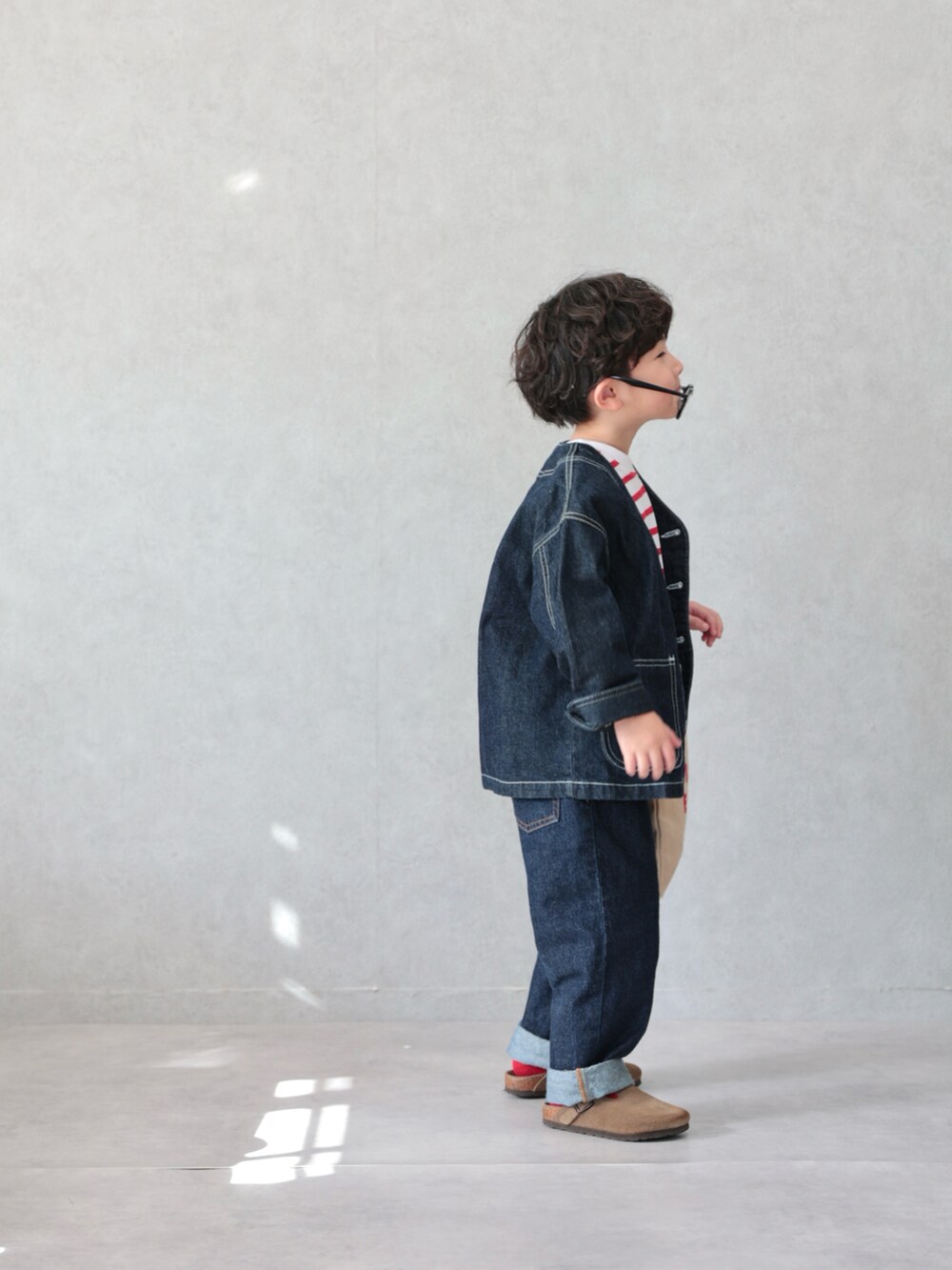 ブルー系のカバーオール、レッド系のTシャツ/カットソー、ブルー系のデニムパンツを着用したキッズの春コーディネートの3枚目の写真