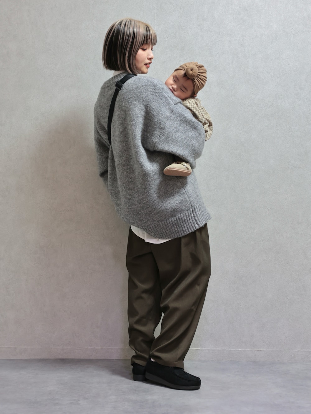 グレー系のニット/セーター、グリーン系のスラックス、ブラック系のモカシン/デッキシューズを着用したキッズの冬コーディネートの3枚目の写真