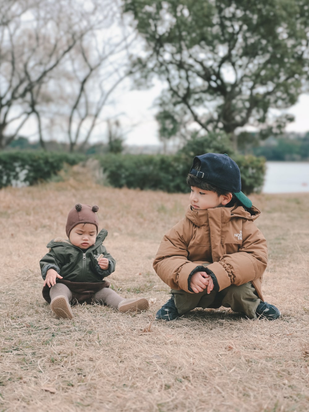ブラウン系のその他アウター、グリーン系のカーゴパンツ、ブルー系のスニーカーを着用したキッズの冬コーディネートの5枚目の写真