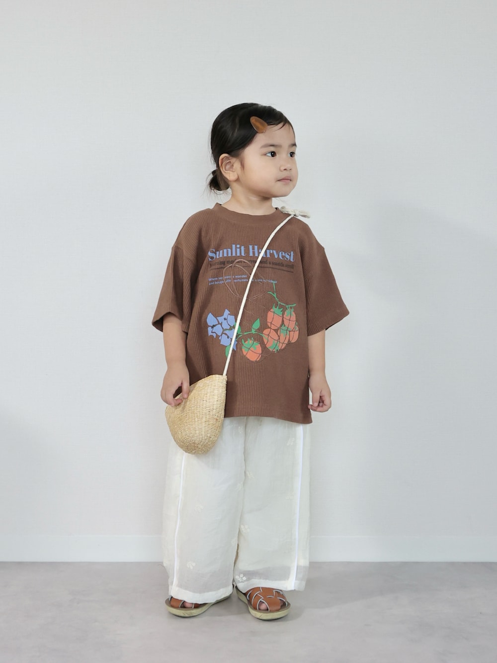 ブラウン系のTシャツ/カットソー、ホワイト系のその他パンツ、ブラウン系のサンダルを着用したキッズの夏コーディネートの2枚目の写真