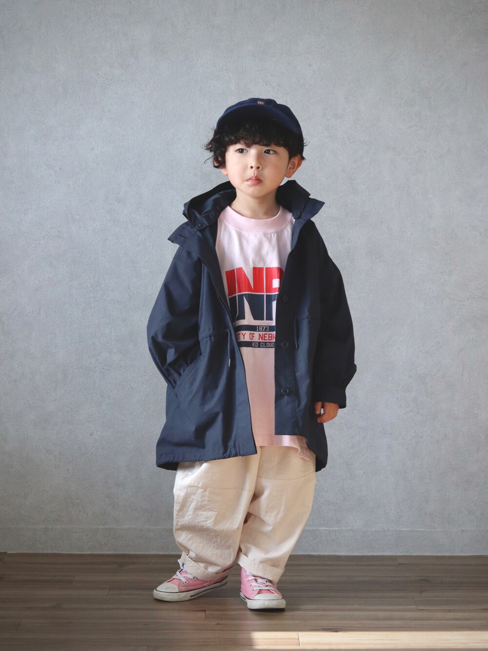 ブラック系のステンカラーコート、ピンク系のTシャツ/カットソー、ホワイト系のその他パンツを着用したキッズの春コーディネートの2枚目の写真