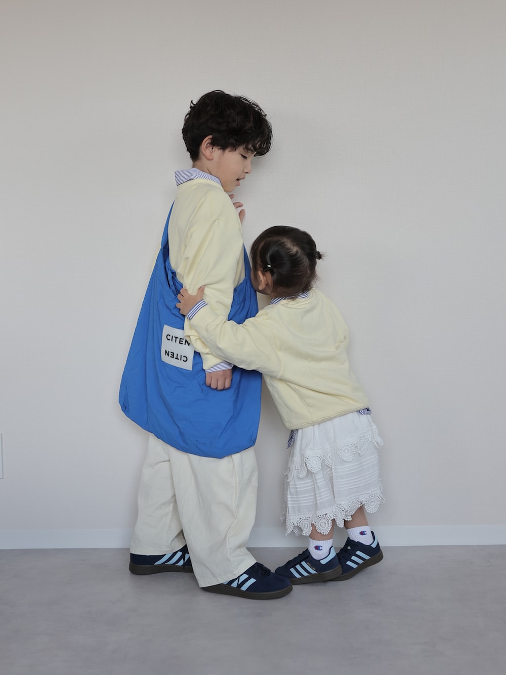 イエロー系のトップス、ブルー系のシャツ/ブラウス、ホワイト系のカーゴパンツを着用したキッズの春コーディネートの2枚目の写真