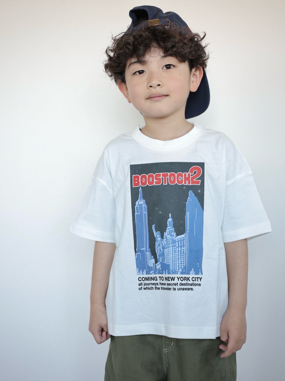 グリーン系のパンツ、ホワイト系のスニーカー、ホワイト系のTシャツ/カットソーを着用したキッズの春コーディネートの2枚目の写真