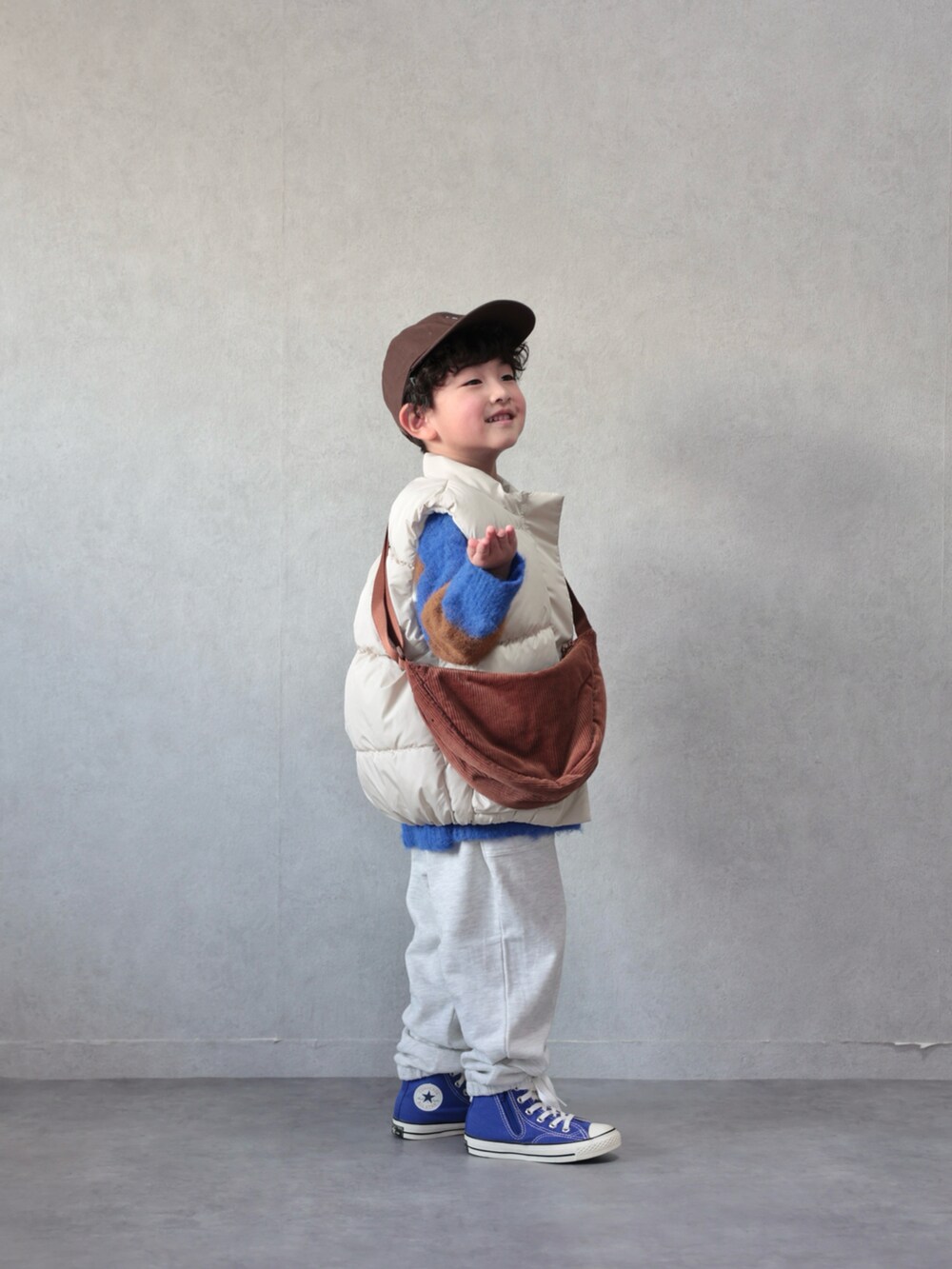ホワイト系のベスト、ブルー系のニット/セーター、ベージュ系のその他パンツを着用したキッズの冬コーディネートの2枚目の写真