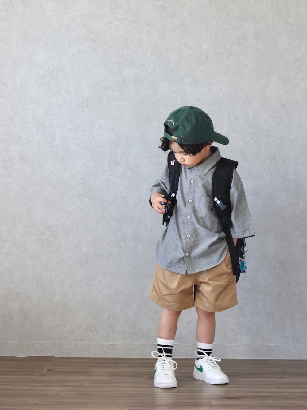 ブラック系のシャツ/ブラウス、ベージュ系のチノパンツ、ベージュ系のスニーカーを着用したキッズの春コーディネートの4枚目の写真