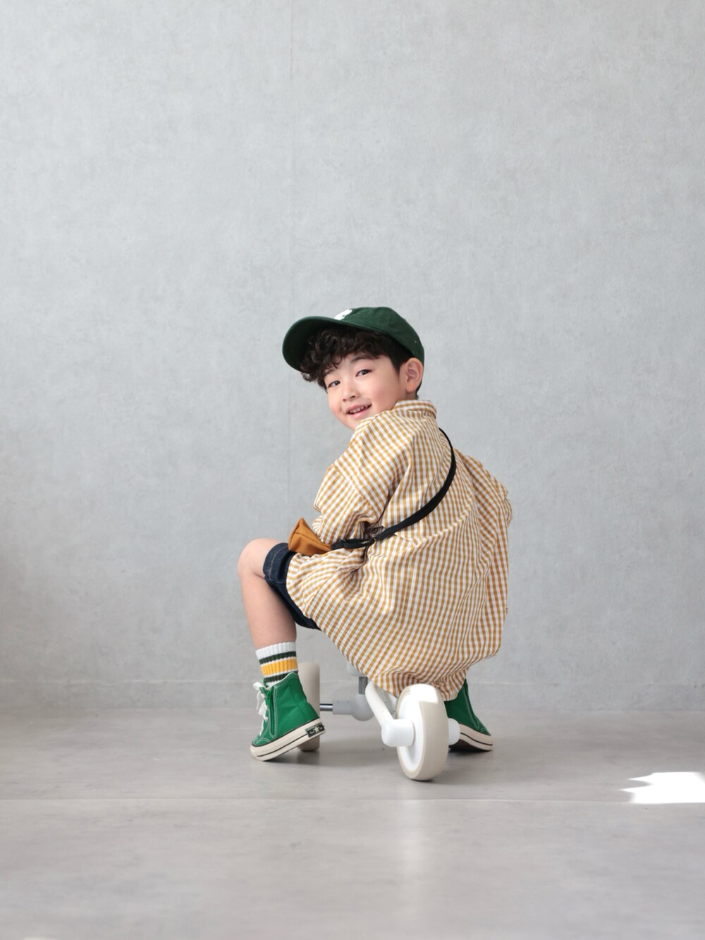 イエロー系のシャツ/ブラウス、ブルー系のデニムパンツ、グリーン系のスニーカーを着用したキッズの春コーディネートの5枚目の写真