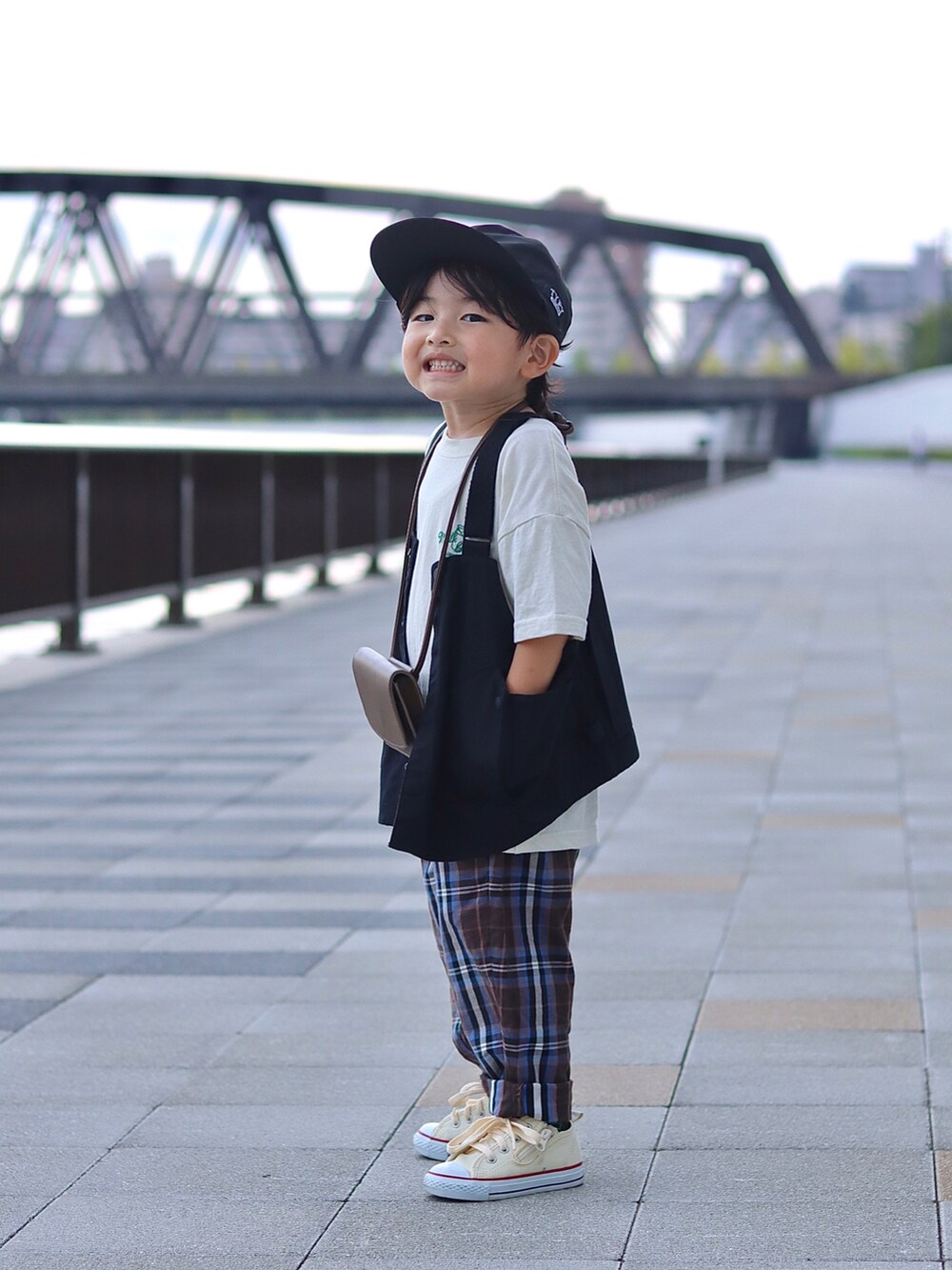 ホワイト系のTシャツ/カットソー、ブラック系のベスト、ブラウン系のパンツを着用したキッズの秋コーディネートの4枚目の写真