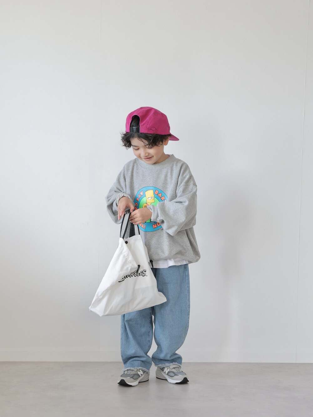 グレー系のスウェット、ブラック系のトップス、ブルー系のデニムパンツを着用したキッズの冬コーディネートの4枚目の写真