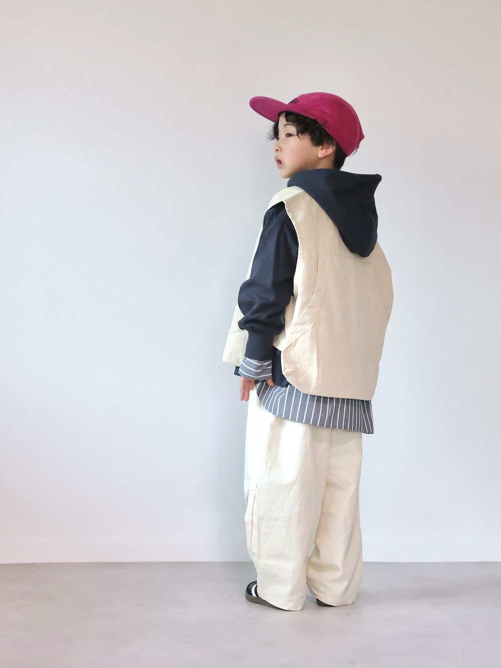 ホワイト系のベスト、ブルー系のスウェット、ブラック系のシャツ/ブラウスを着用したキッズの冬コーディネートの3枚目の写真