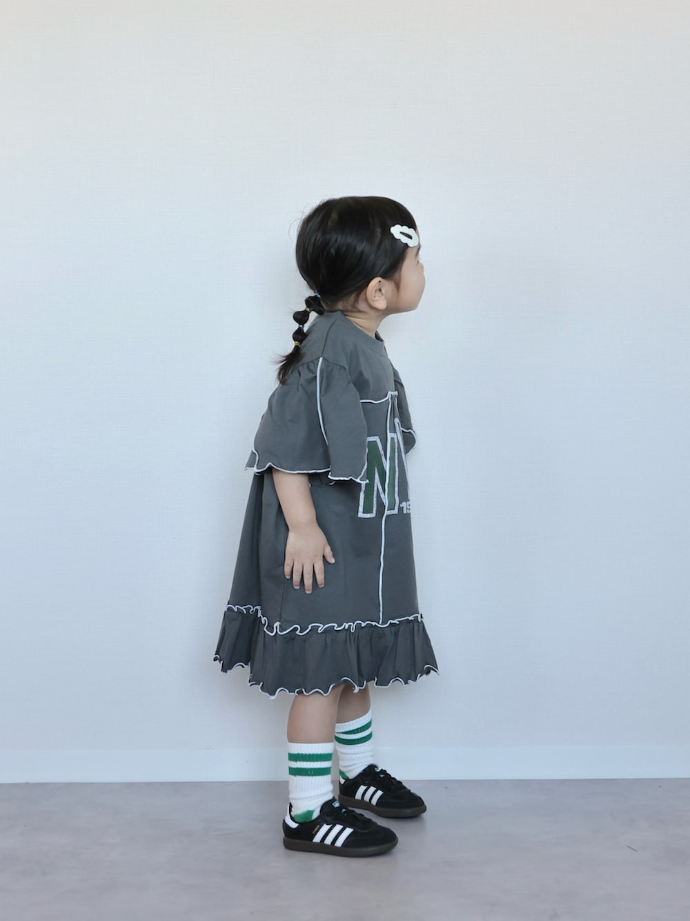 グレー系のワンピース、ブラック系のスニーカー、ブラック系のスニーカーを着用したキッズの春コーディネートの3枚目の写真