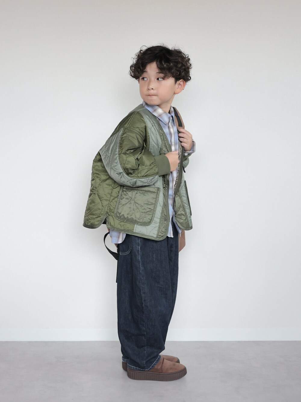 ブルー系のシャツ/ブラウス、グリーン系のブルゾン、ブラウン系のバックパック/リュックを着用したキッズの秋コーディネートの2枚目の写真