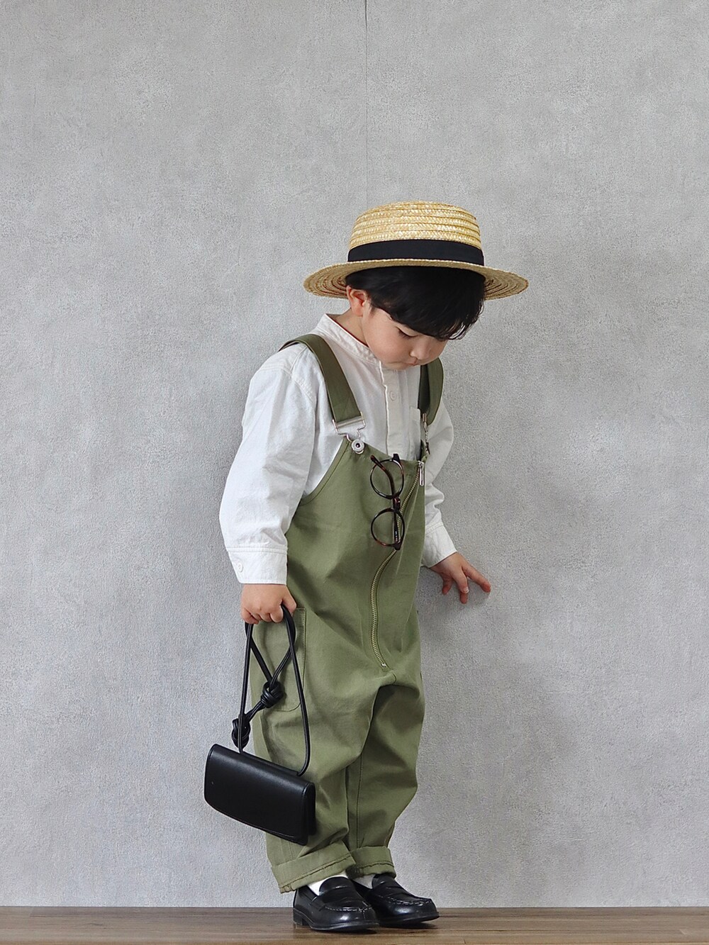 グリーン系のサロペット/オーバーオール、ホワイト系のシャツ/ブラウス、ブラック系のローファーを着用したキッズの春コーディネートの5枚目の写真