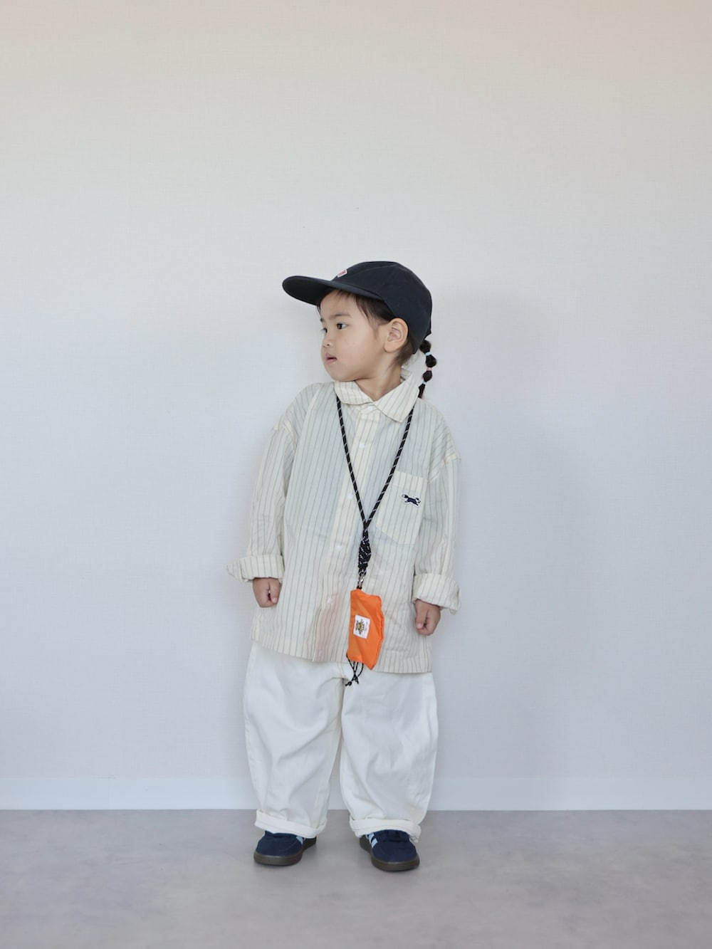 グリーン系のベスト、イエロー系のシャツ/ブラウス、ブルー系のスニーカーを着用したキッズの春コーディネートの3枚目の写真