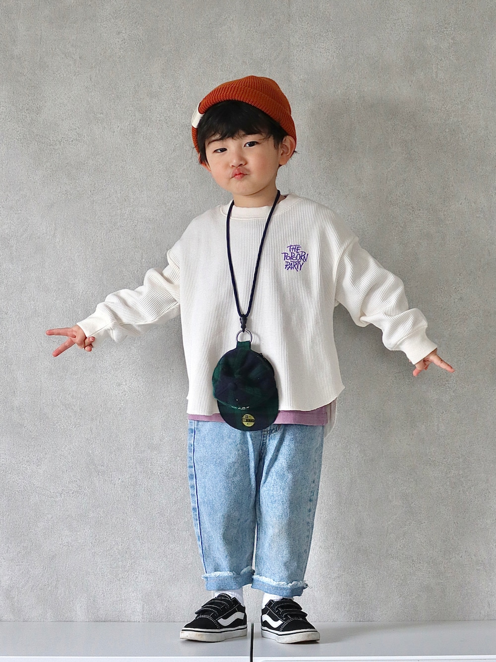 ホワイト系のTシャツ/カットソー、ブルー系のデニムパンツ、ブラック系のスニーカーを着用したキッズの冬コーディネートの3枚目の写真