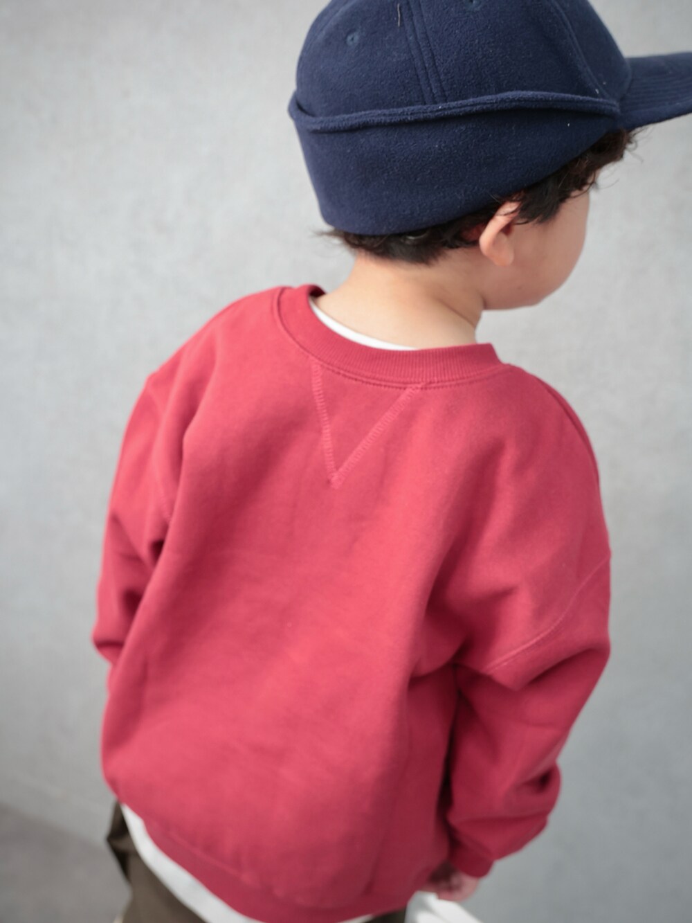 レッド系のスウェット、グリーン系のその他パンツ、ホワイト系のTシャツ/カットソーを着用したキッズの冬コーディネートの3枚目の写真
