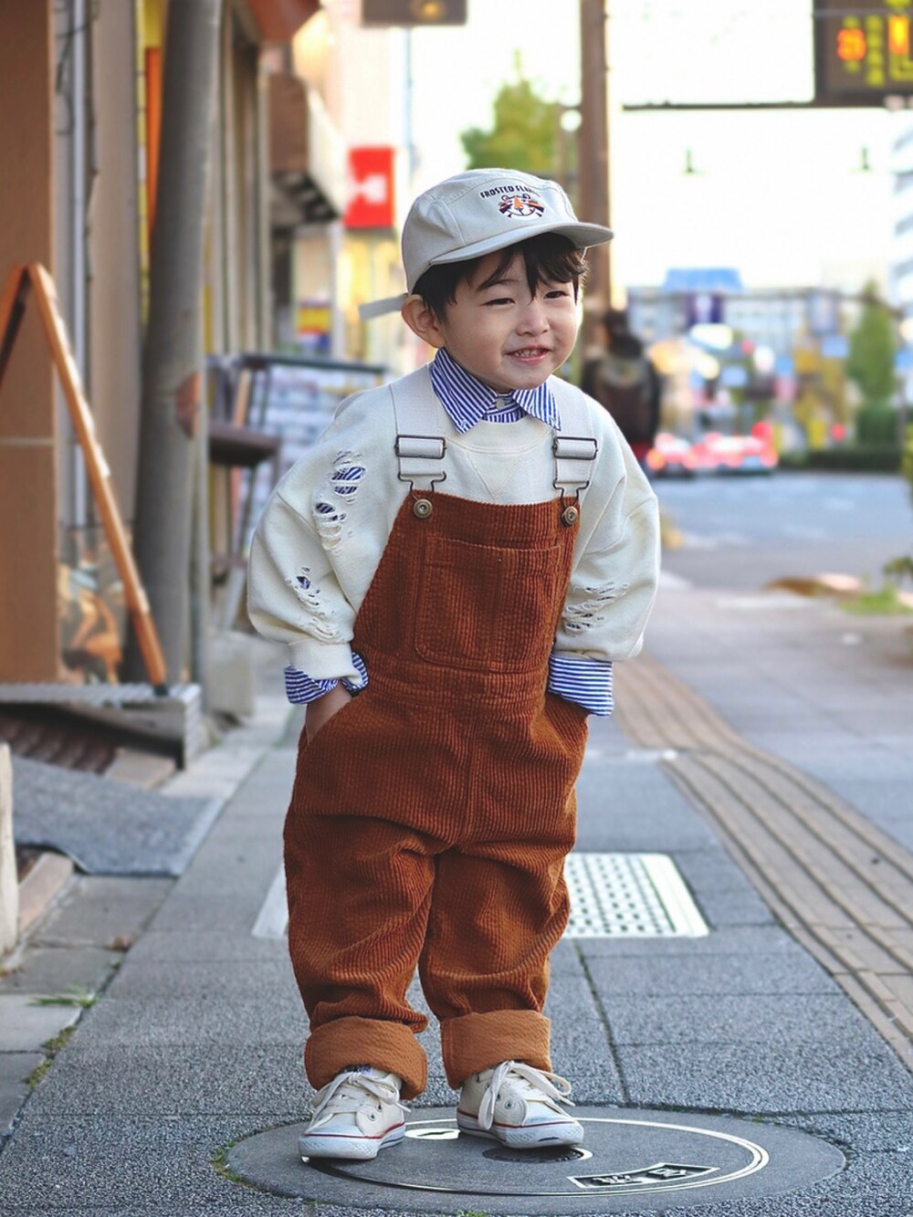 ホワイト系のスウェット、ブルー系のシャツ/ブラウス、イエロー系のサロペット/オーバーオールを着用したキッズの秋コーディネートの2枚目の写真