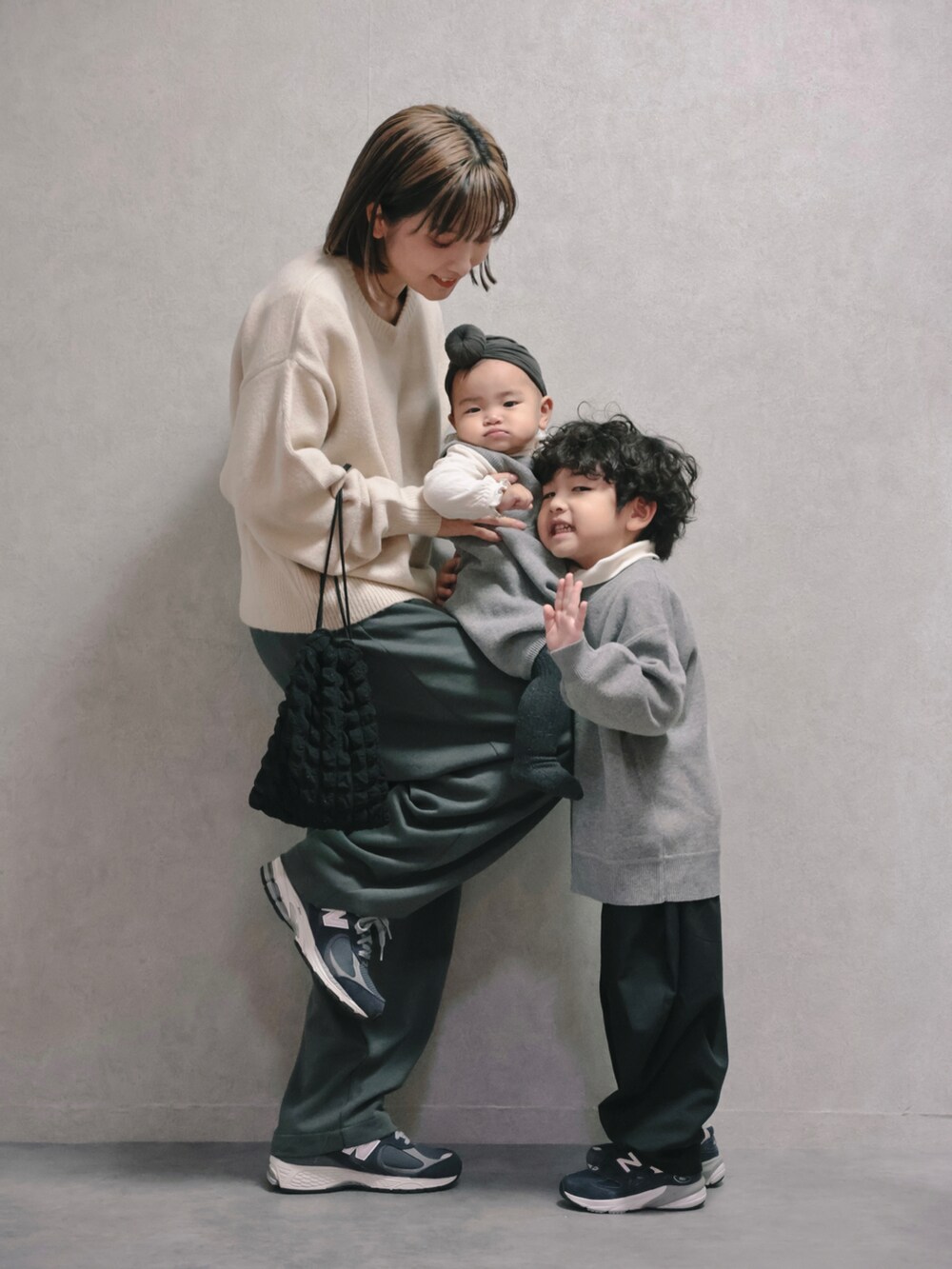 ブルー系のその他アウター、ホワイト系のニット/セーター、ブラック系のショルダーバッグを着用したキッズの秋コーディネートの2枚目の写真