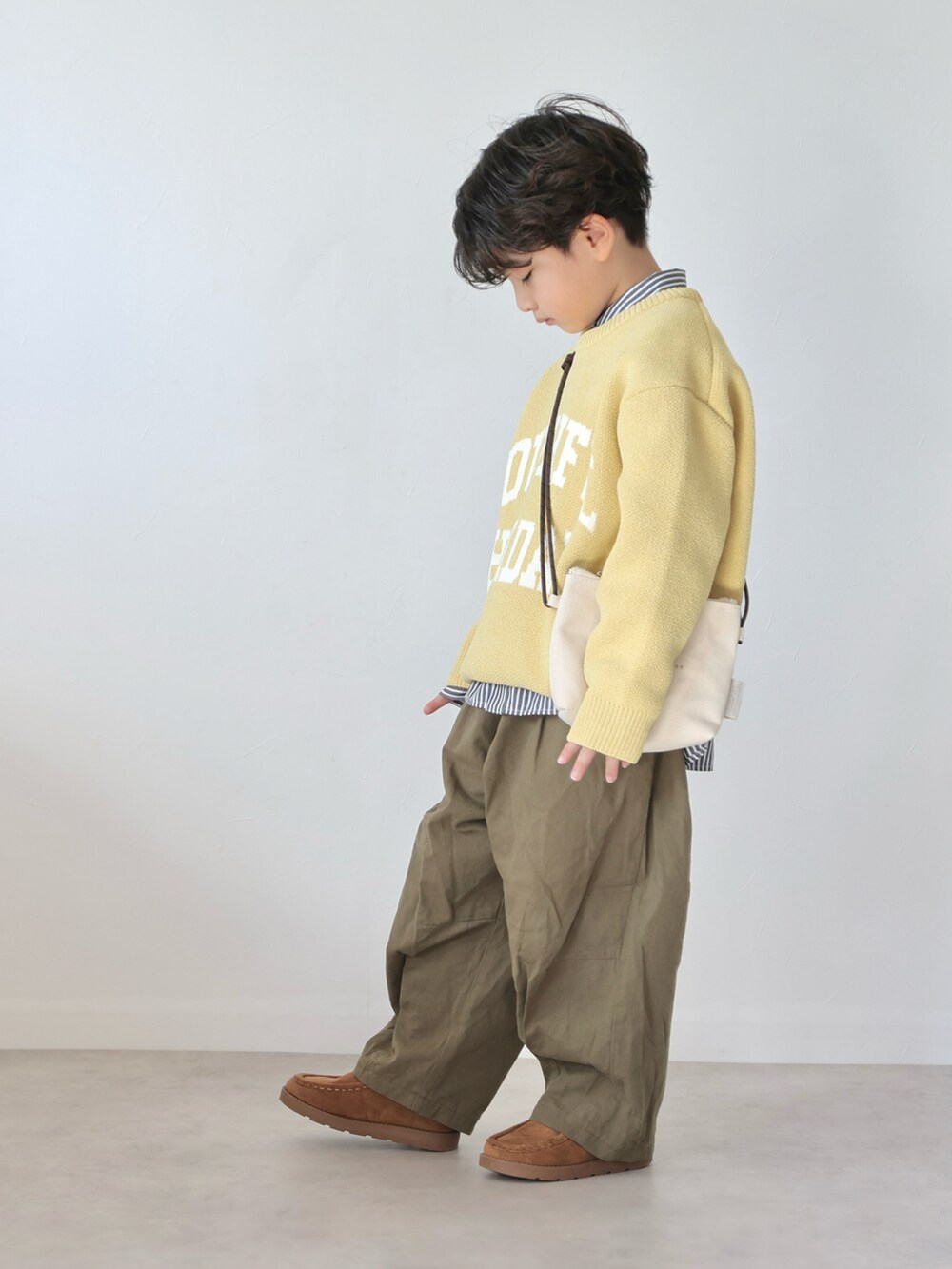 イエロー系のニット/セーター、ブラック系のシャツ/ブラウス、グリーン系のカーゴパンツを着用したキッズの冬コーディネートの2枚目の写真