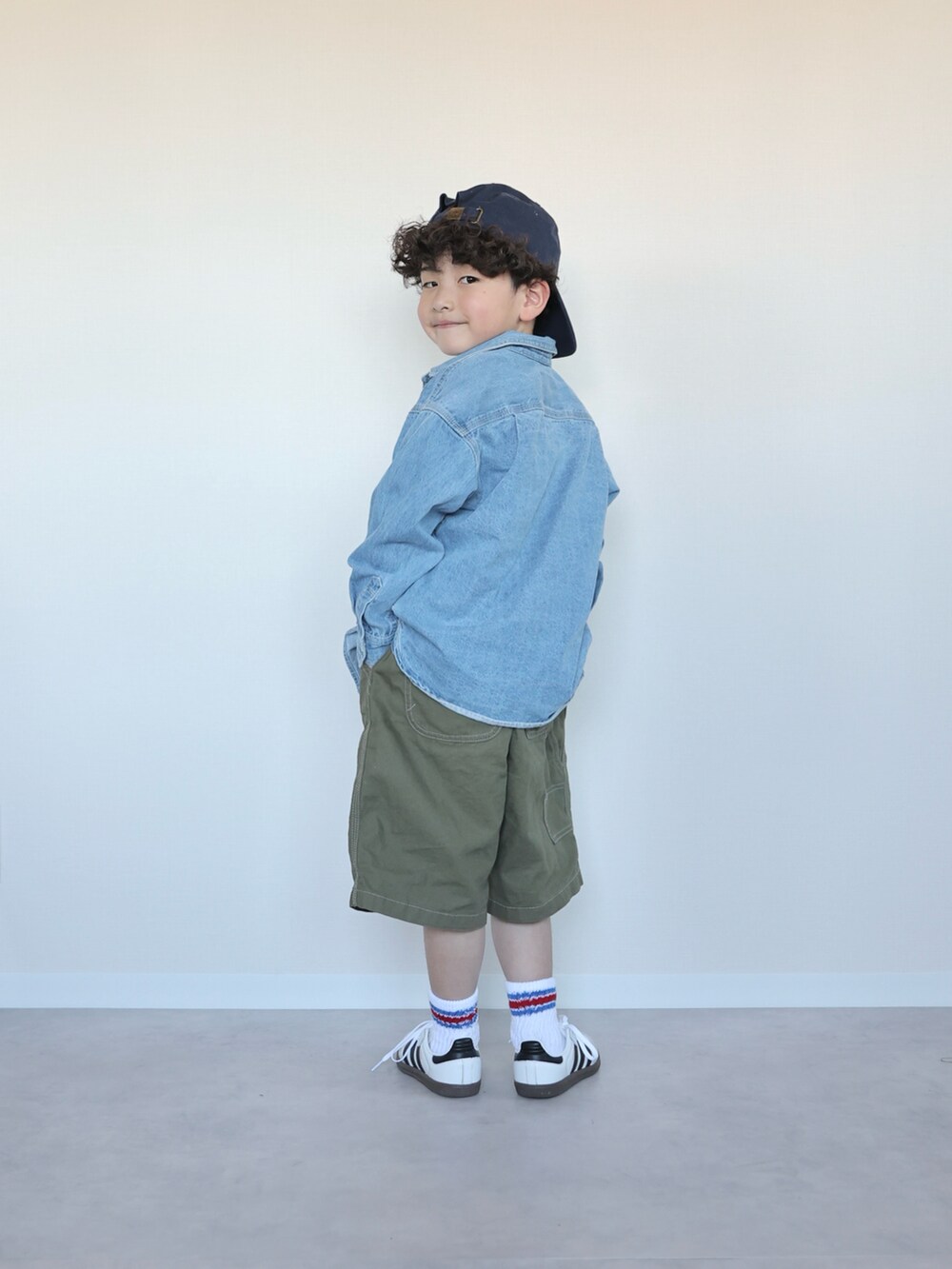 グリーン系のパンツ、ホワイト系のスニーカー、ホワイト系のTシャツ/カットソーを着用したキッズの春コーディネートの5枚目の写真