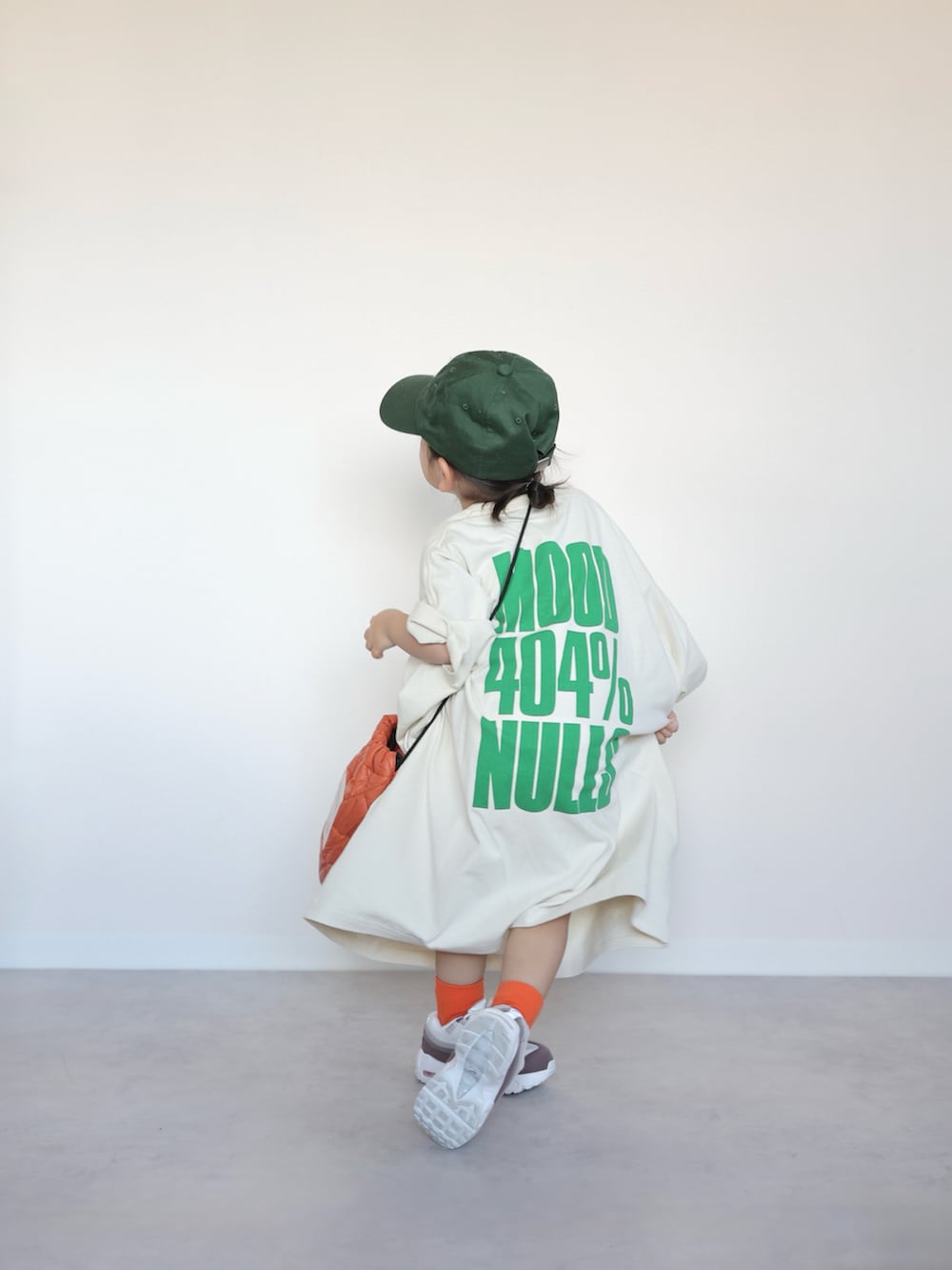 ホワイト系のTシャツ/カットソー、オレンジ系のショルダーバッグ、ホワイト系のスニーカーを着用したキッズの春コーディネートの4枚目の写真