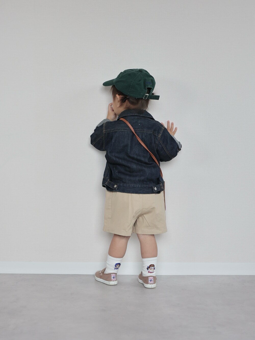 ブルー系のデニムジャケット、ホワイト系のトップス、ベージュ系のパンツを着用したキッズの春コーディネートの3枚目の写真