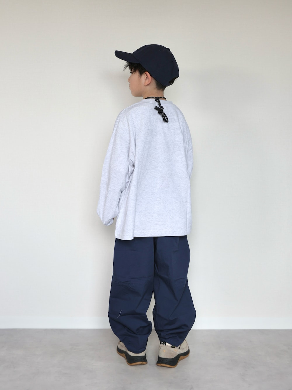 グレー系のTシャツ/カットソー、ブルー系のデニムパンツ、ベージュ系のスニーカーを着用したキッズの冬コーディネートの4枚目の写真