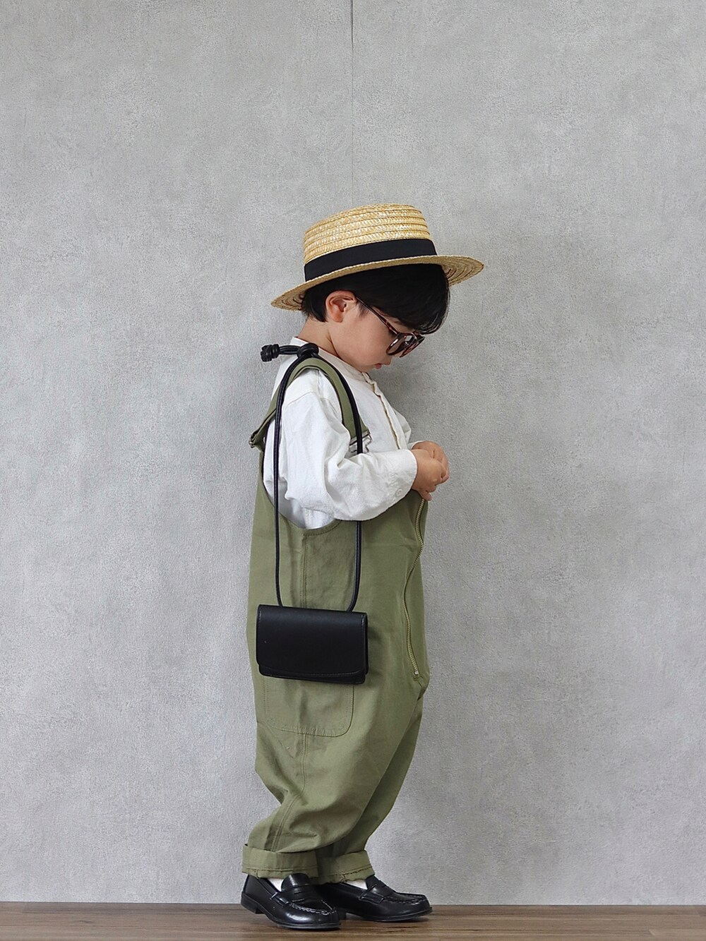 グリーン系のサロペット/オーバーオール、ホワイト系のシャツ/ブラウス、ブラック系のローファーを着用したキッズの春コーディネートの2枚目の写真