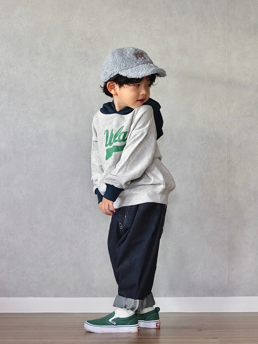 ホワイト系のパーカー、ブルー系のデニムパンツ、グリーン系のスニーカーを着用したキッズの秋コーディネートの3枚目の写真
