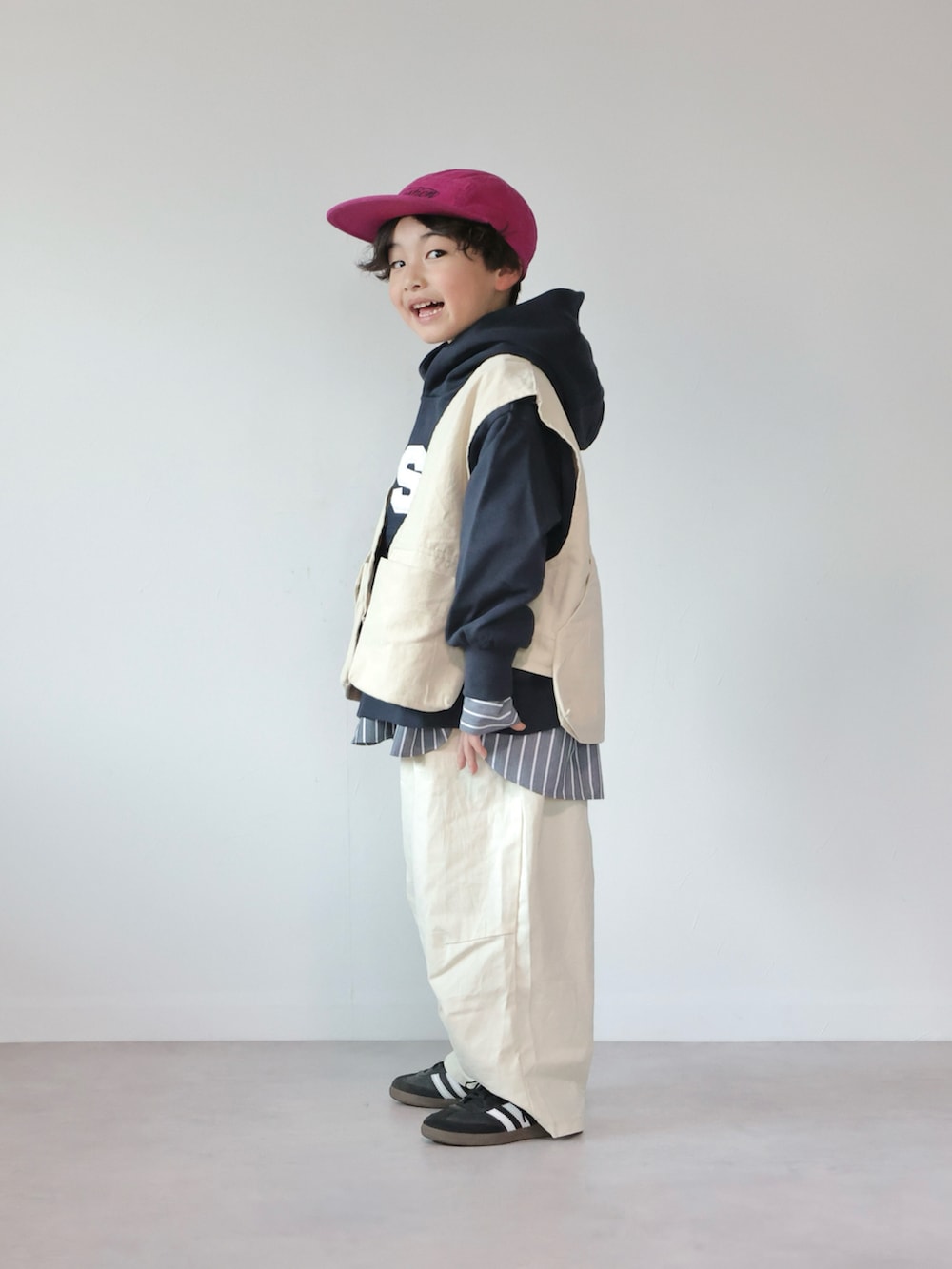 ホワイト系のベスト、ブルー系のスウェット、ブラック系のシャツ/ブラウスを着用したキッズの冬コーディネートの2枚目の写真