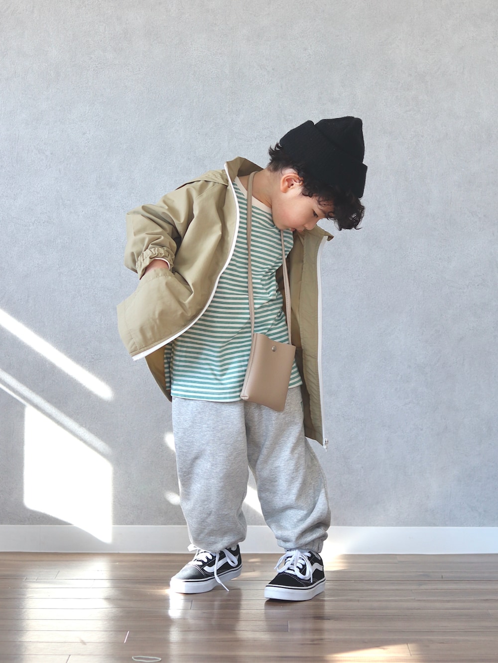 グリーン系のTシャツ/カットソー、ホワイト系のスウェットパンツ、ベージュ系のショルダーバッグを着用したキッズの冬コーディネートの5枚目の写真