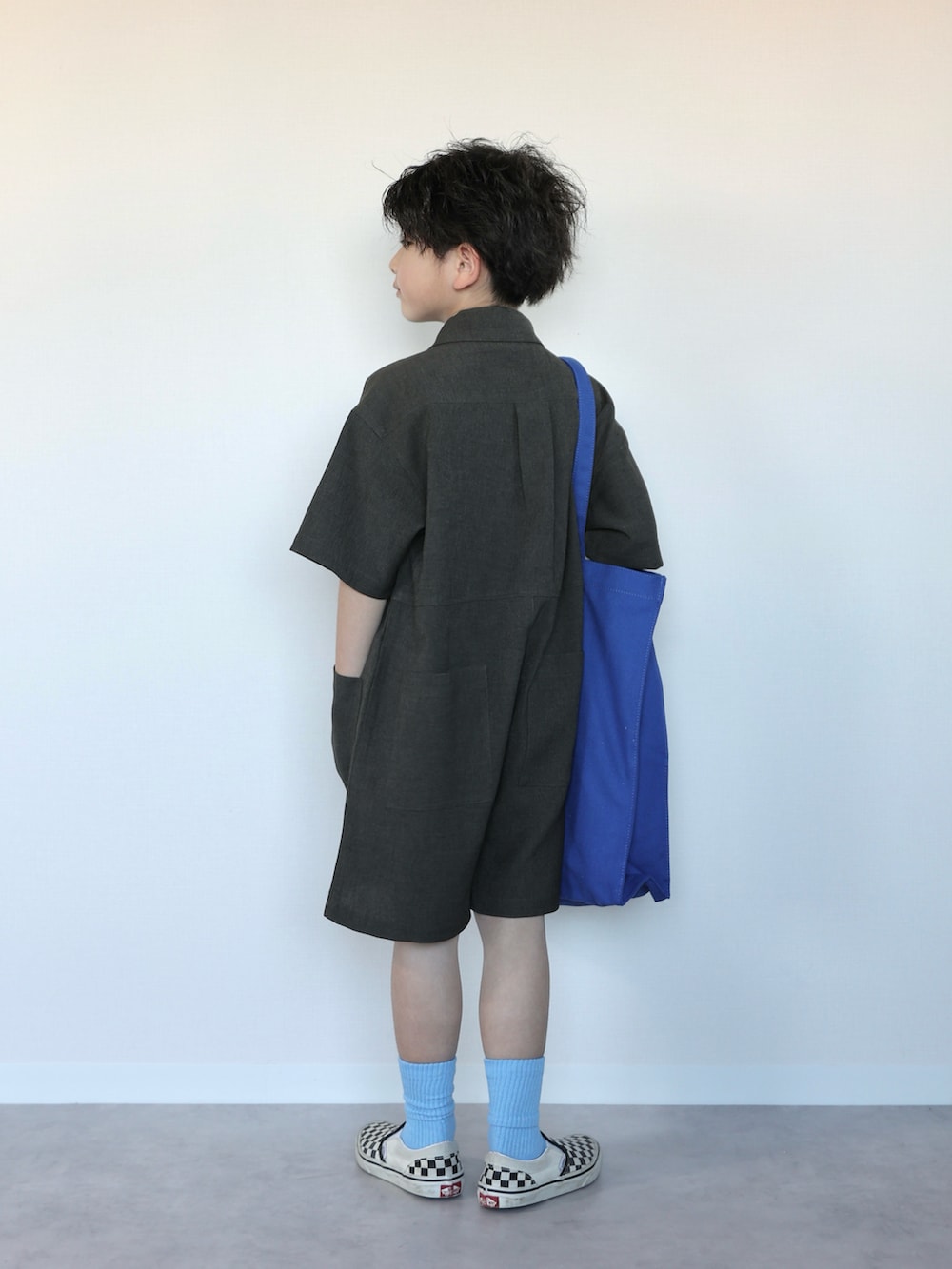 グレー系のつなぎ/オールインワン、ブルー系のトートバッグ、ブラック系のスリッポンを着用したキッズの春コーディネートの3枚目の写真