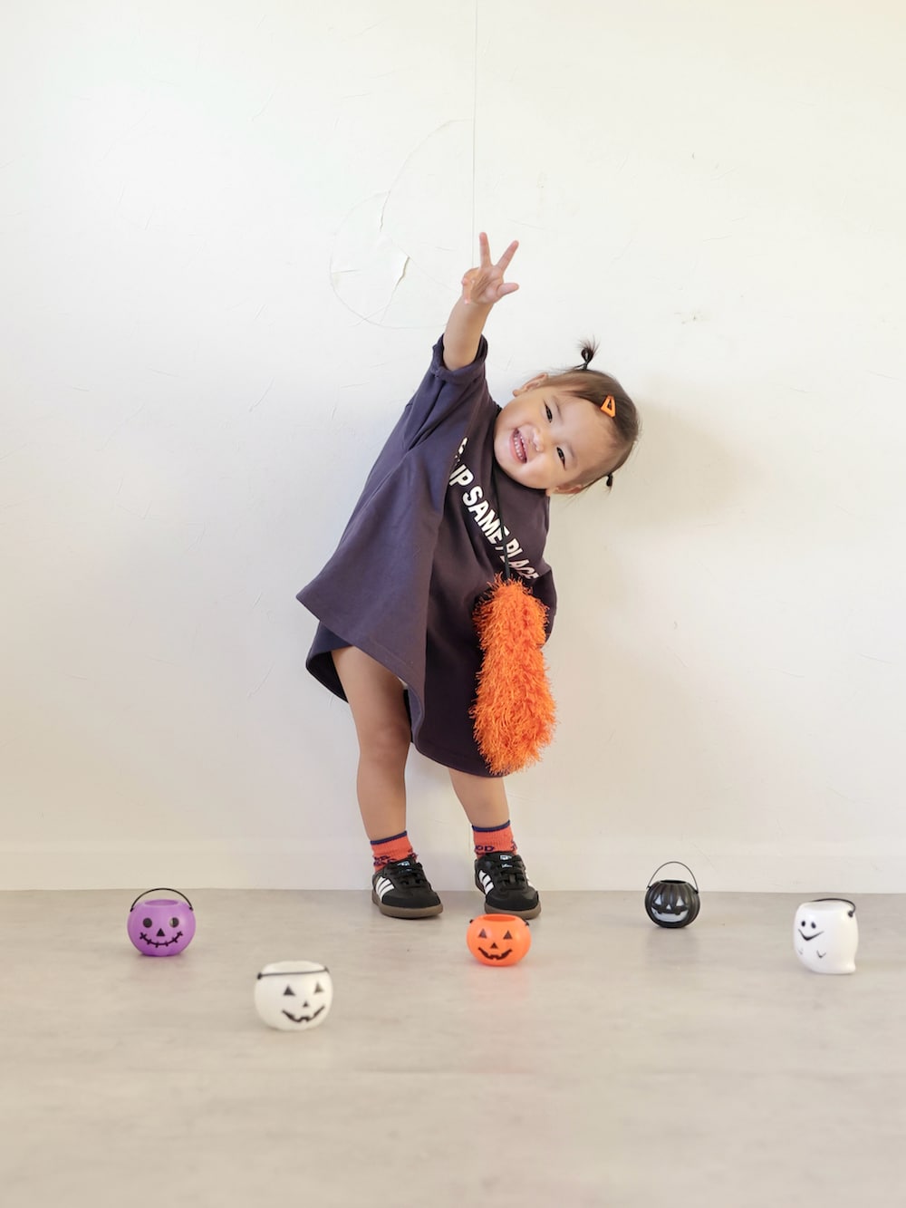 ブルー系のワンピース、オレンジ系のショルダーバッグ、ブラック系のスニーカーを着用したキッズの秋コーディネートの5枚目の写真