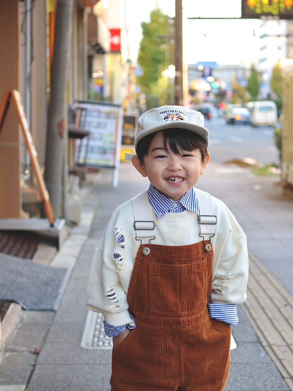 ホワイト系のスウェット、ブルー系のシャツ/ブラウス、イエロー系のサロペット/オーバーオールを着用したキッズの秋コーディネートの3枚目の写真