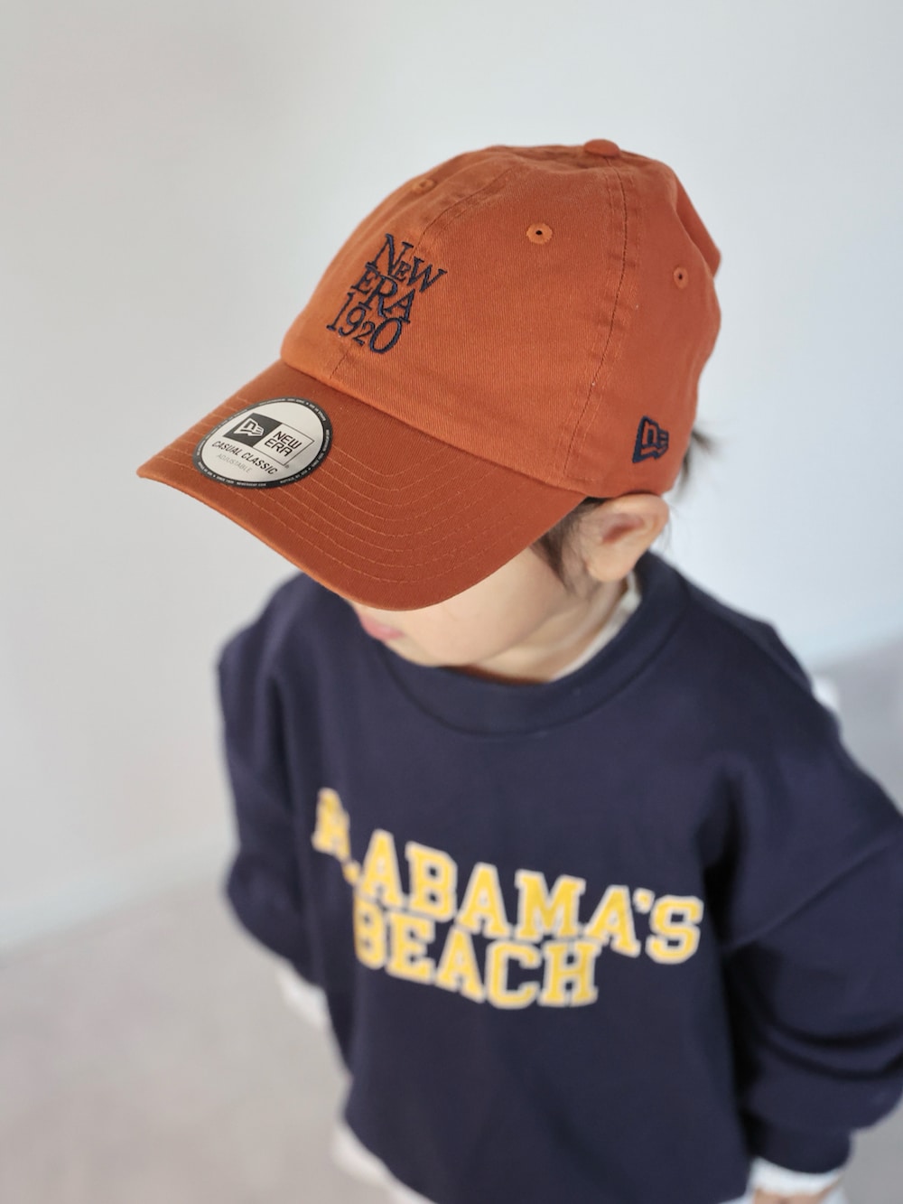 ブラウン系のモカシン/デッキシューズ、ブルー系のスウェット、ホワイト系のワンピースを着用したキッズの冬コーディネートの4枚目の写真