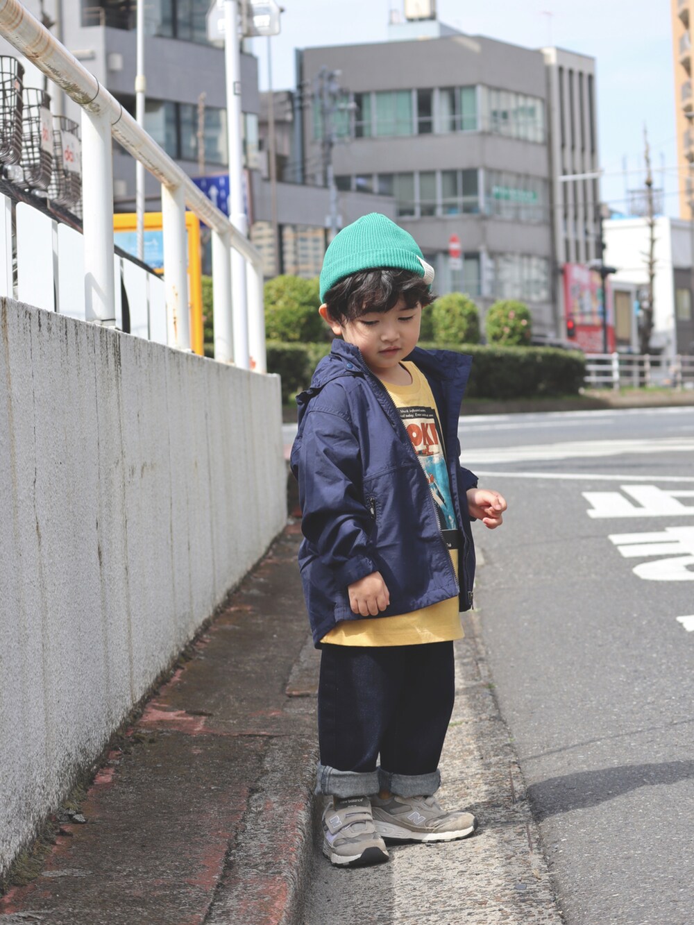ブルー系のナイロンジャケット、イエロー系のTシャツ/カットソー、ブルー系のデニムパンツを着用したキッズの春コーディネートの3枚目の写真