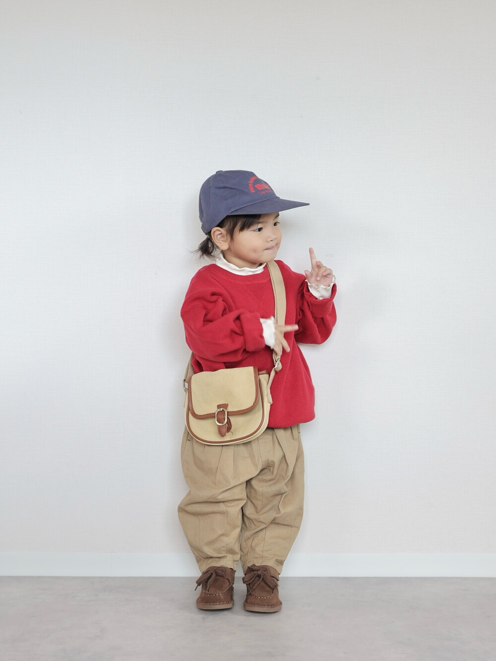 レッド系のニット/セーター、ベージュ系のその他パンツ、ブラウン系のモカシン/デッキシューズを着用したキッズの秋コーディネートの4枚目の写真