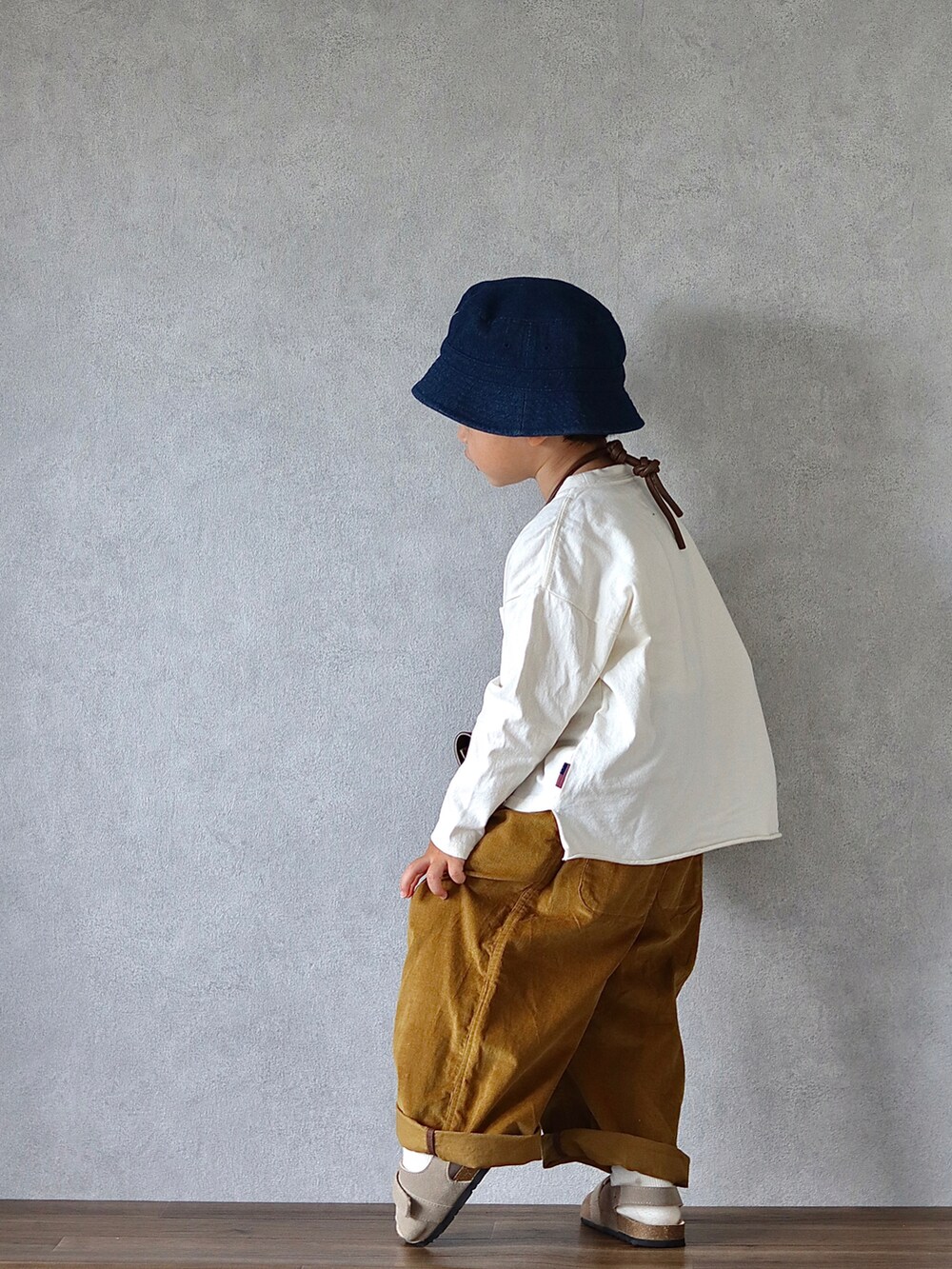 ホワイト系のTシャツ/カットソー、ブラウン系のパンツ、ベージュ系のサンダルを着用したキッズの秋コーディネートの4枚目の写真