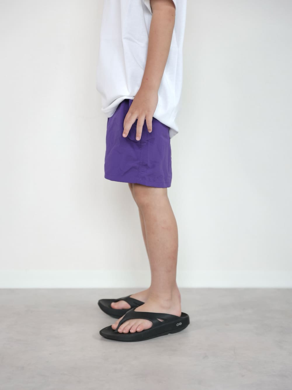 パープル系のその他パンツ、ホワイト系のTシャツ/カットソー、ブラック系のサンダルを着用したキッズの夏コーディネートの2枚目の写真