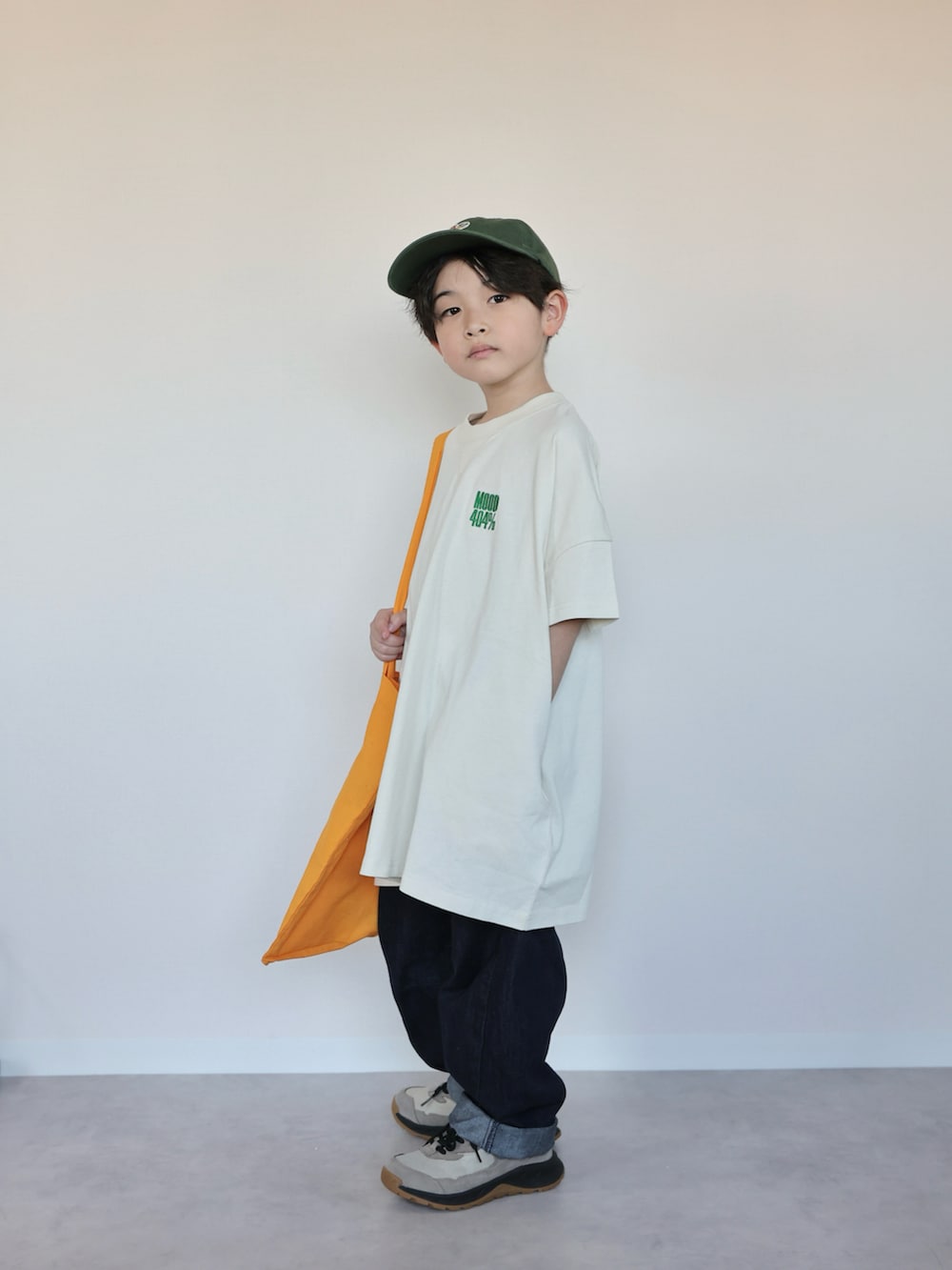 ホワイト系のTシャツ/カットソー、オレンジ系のトートバッグ、ベージュ系のスニーカーを着用したキッズの春コーディネートの5枚目の写真