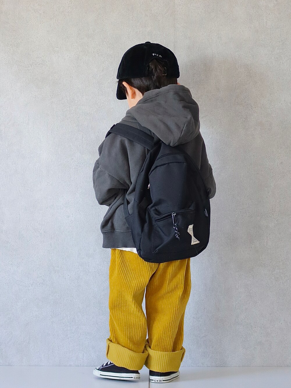ブラック系のパーカー、ホワイト系のニット/セーター、イエロー系のその他パンツを着用したキッズの冬コーディネートの3枚目の写真