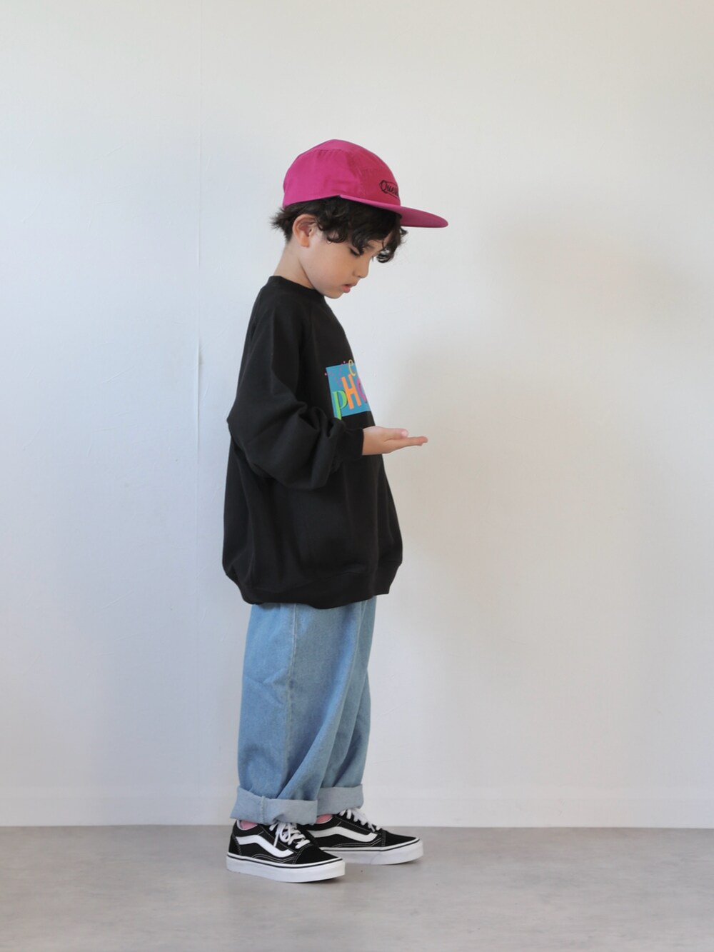 ブラック系のスウェット、ブルー系のデニムパンツ、ブラック系のスニーカーを着用したキッズの秋コーディネートの2枚目の写真