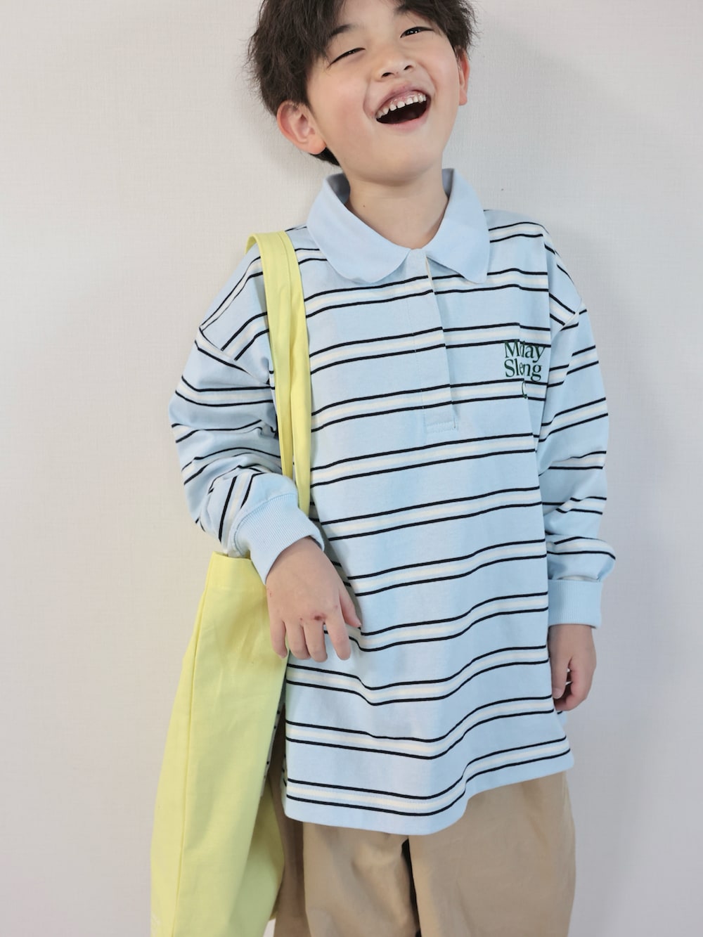 ブルー系のポロシャツ、ベージュ系のその他パンツ、ブルー系のスニーカーを着用したキッズの春コーディネートの2枚目の写真